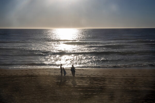 Two people are standing at Avalon Beach in Sydney, Australia 