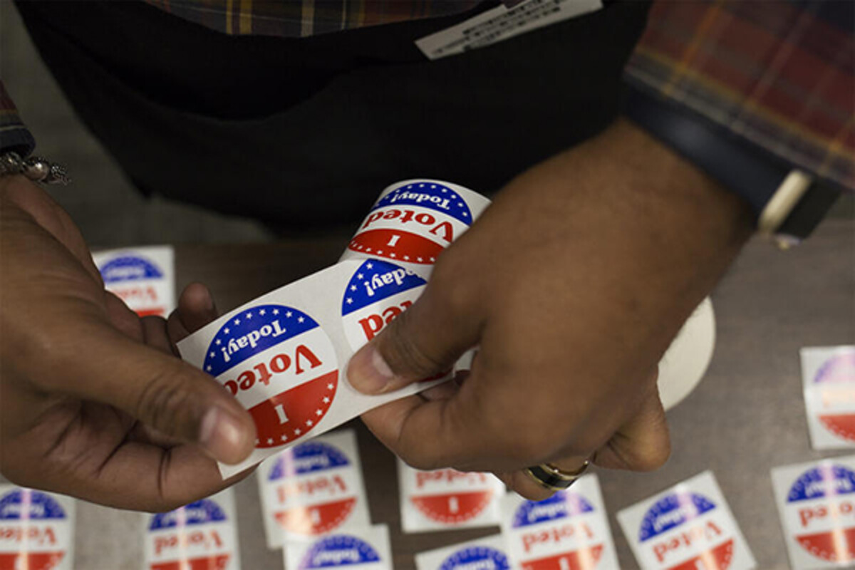 African American person tearing off an I Voted Today sticker
