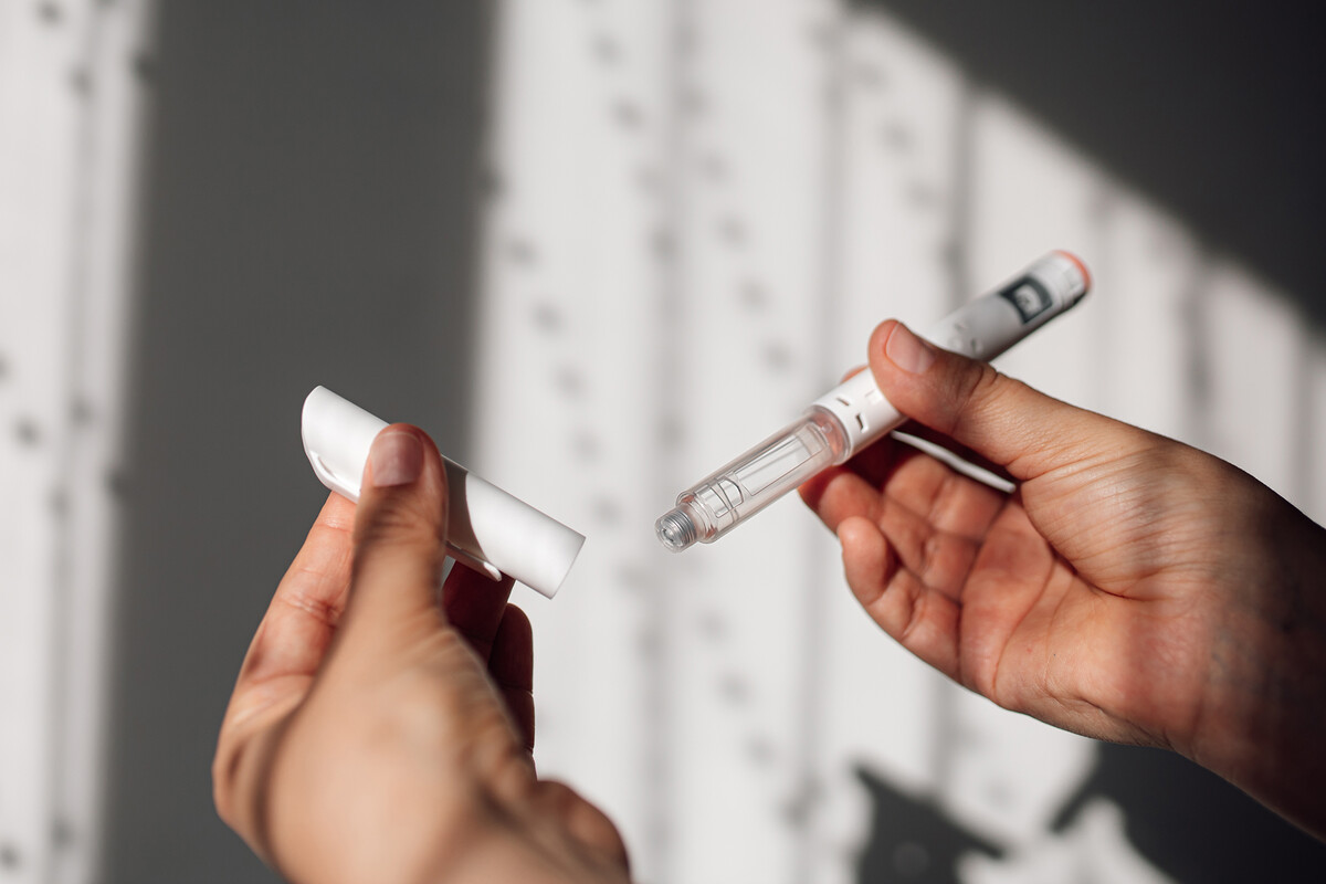 A person holding a GLP-1 applicator.