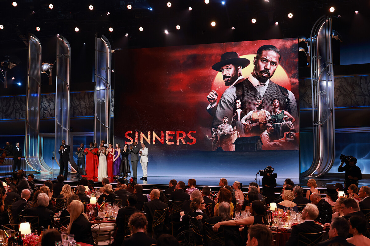 The cast of Sinners on stage at the Oscars receiving an award.
