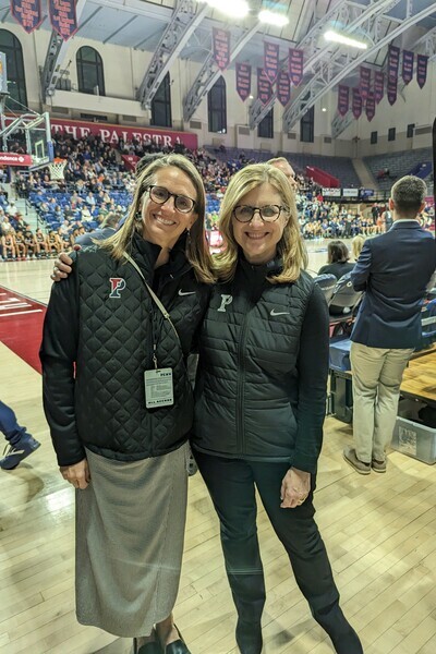 Director of Athletics Alanna Shanahan, left, and President Liz Magill take in the men’s basketball game against Yale on Friday at the Palestra.