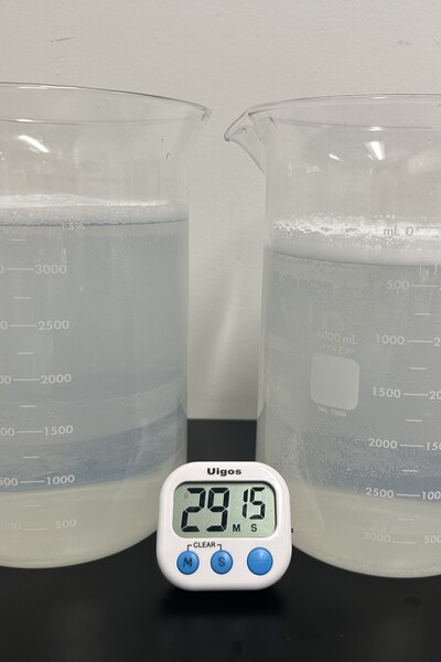 Two lab beakers with fluid.